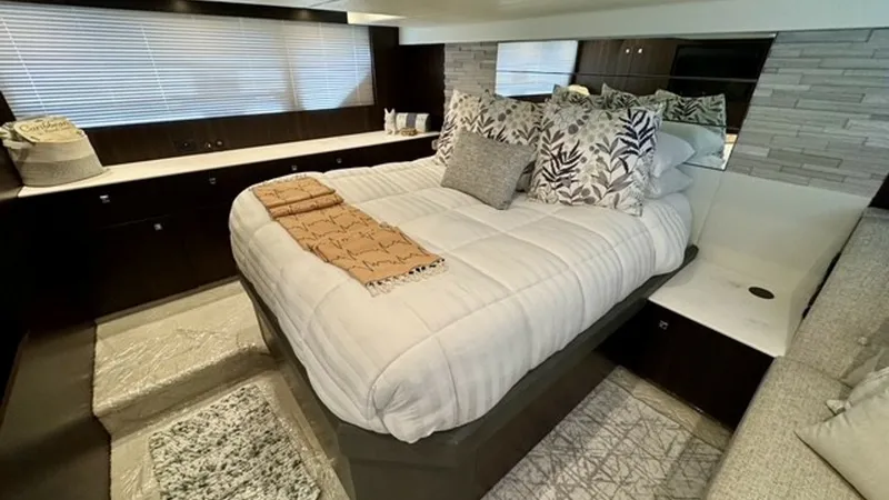 Slide: The Image of Luxurious Forward Stateroom This elegant forward stateroom on the 2023 Cruisers Yachts 50 Cantius offers a spacious and inviting retreat. The plush double bed is complemented by tasteful bedding and decorative pillows, creating a cozy and upscale ambiance. Ample natural light filter - 6489135