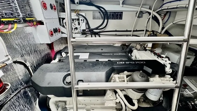 Slide: The Image of Engine Room with Volvo Penta This image showcases the engine room of the 2023 Cruisers Yachts 50 Cantius, featuring a powerful Volvo Penta D8-IPS700 engine. The space is well-organized with neatly arranged wiring and modern control panels, ensuring optimal performance and ease of mai - 6489164