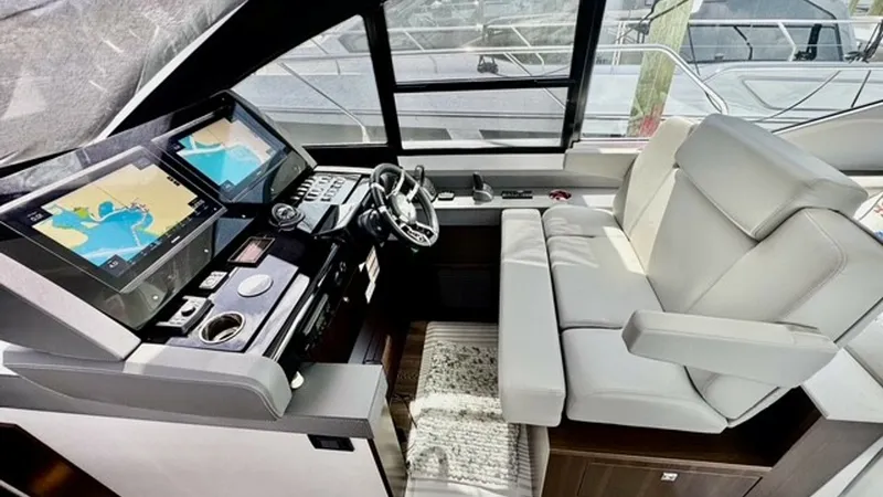 Slide: The Image of Helm Station with Dual Displays The helm station of the 2023 Cruisers Yachts 50 Cantius offers a modern design with dual navigation displays for enhanced control and visibility. Luxurious seating provides comfort for the captain, while the panoramic windows deliver an unobstructed view - 6489145
