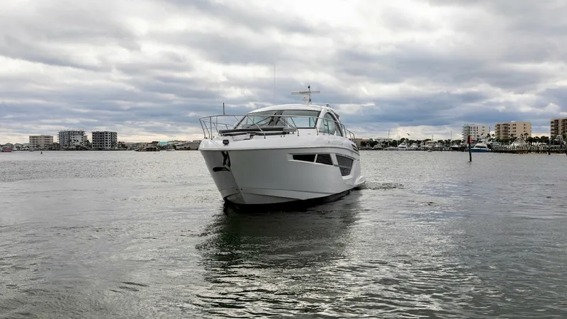 Slide: The Image of Bow View on Open Water The 2023 Cruisers Yachts 50 Cantius is showcased with its sleek bow cutting through open water. This vessel features modern lines and expansive windows, providing a striking profile and excellent visibility. The clean, contemporary design is complemented - 6489167