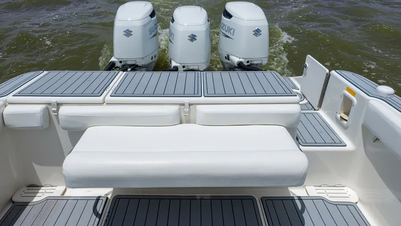 Slide: The Image of Aft Deck with Triple Engines This 2005 Triton 351 Center Console showcases a spacious aft deck equipped with triple Suzuki outboard engines, ensuring powerful performance on the water. The deck features sleek, non-slip surfaces and comfortable seating, providing both functionality an - 6687464