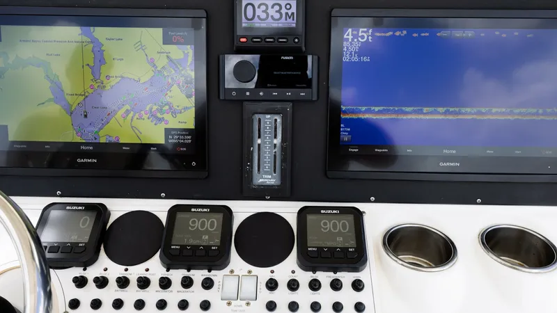 Slide: The Image of Advanced Helm Electronics Display This helm station features dual Garmin displays providing comprehensive navigation and sonar information for the Triton 351 Center Console. The intuitive layout includes multiple digital gauges and a well-organized control panel for easy access to all fun - 6687459