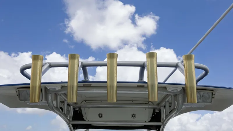 Slide: The Image of T-Top with Rod Holders The 2005 Triton 351 Center Console features a sturdy T-Top equipped with five gold-toned rod holders, ideal for avid anglers. The design offers shade and protection while maintaining a sleek profile against the sky. This functional setup enhances your fis - 6687461