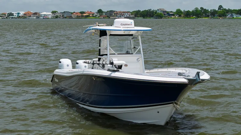 Slide: The Image of Bow and Helm View This Triton 351 Center Console from 2005 showcases a sleek, dark blue hull with a spacious bow area, perfect for fishing or relaxing. The helm is equipped with advanced navigation technology, including a prominent Garmin unit, ensuring precise navigation - 6687492