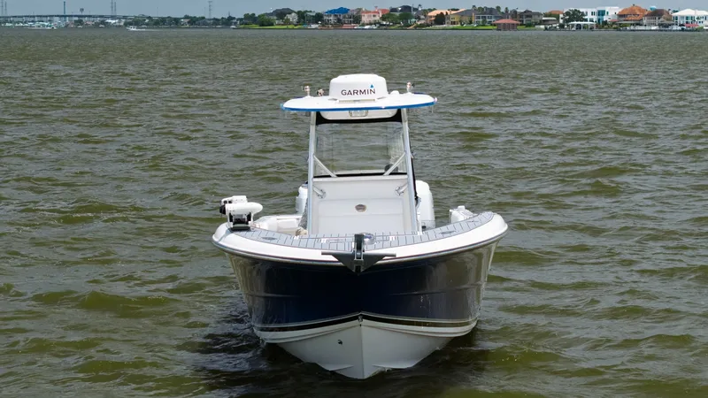 Slide: The Image of Bow View with T-Top This image showcases the bow of the 2005 Triton 351 Center Console, highlighting its sleek, aerodynamic design. The integrated T-top provides shade and houses advanced navigation equipment, including a Garmin radar. The spacious deck offers ample room for - 6687491