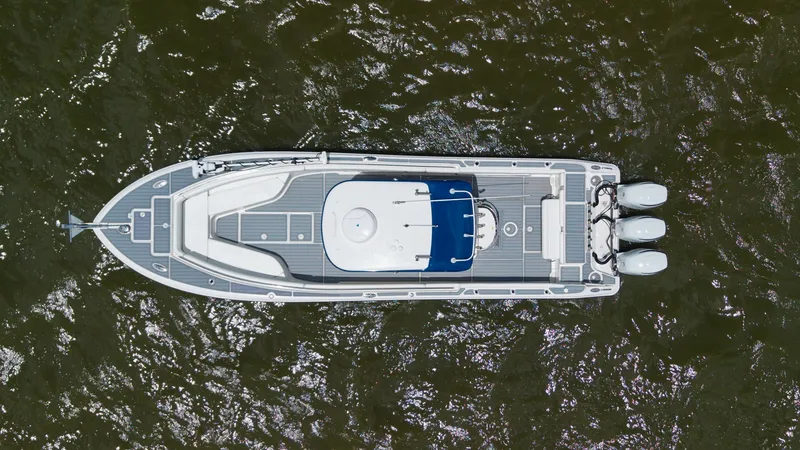 Slide: The Image of Aerial View of Center Console Deck This aerial shot showcases the expansive deck layout of the 2005 Triton 351 Center Console. The vessel features a sleek, modern design with ample space for movement and relaxation. Equipped with triple outboard engines, this boat promises powerful perform - 6687496