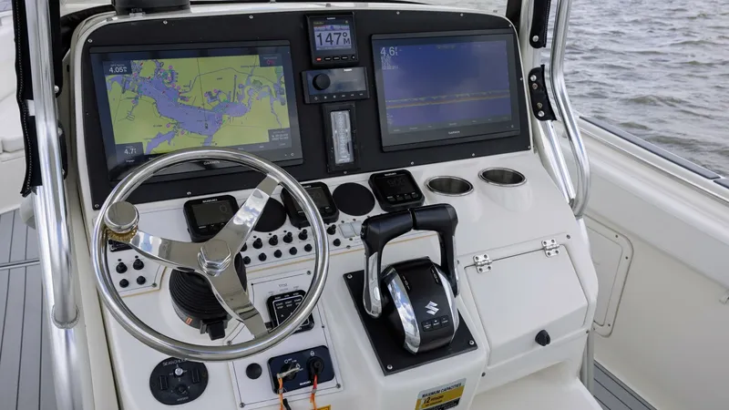 Slide: The Image of Helm Station with Dual Displays The helm station of the 2005 Triton 351 Center Console showcases advanced navigation technology with dual display screens for comprehensive chart plotting and system monitoring. A sleek stainless steel steering wheel and ergonomic throttle controls ensure - 6687455