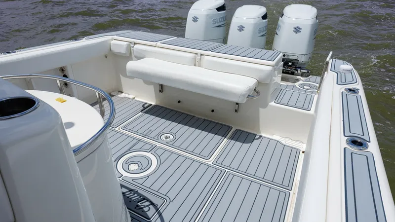 Slide: The Image of Spacious Aft Deck with Seating This 2005 Triton 351 Center Console showcases a well-designed aft deck featuring a comfortable fold-down bench seat. The deck is adorned with sleek, non-slip flooring, providing both style and safety. With ample space and easy access to the powerful outbo - 6687466
