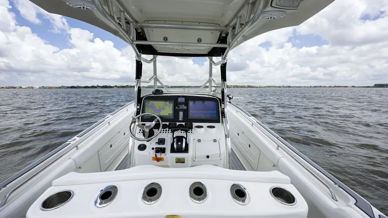 Slide: The Image of Helm and T-Top View This image showcases the helm of the 2005 Triton 351 Center Console, featuring a well-equipped dashboard with dual display screens and a modern steering wheel. The T-top provides excellent shade and integrates lighting for enhanced visibility. The layout - 6687457