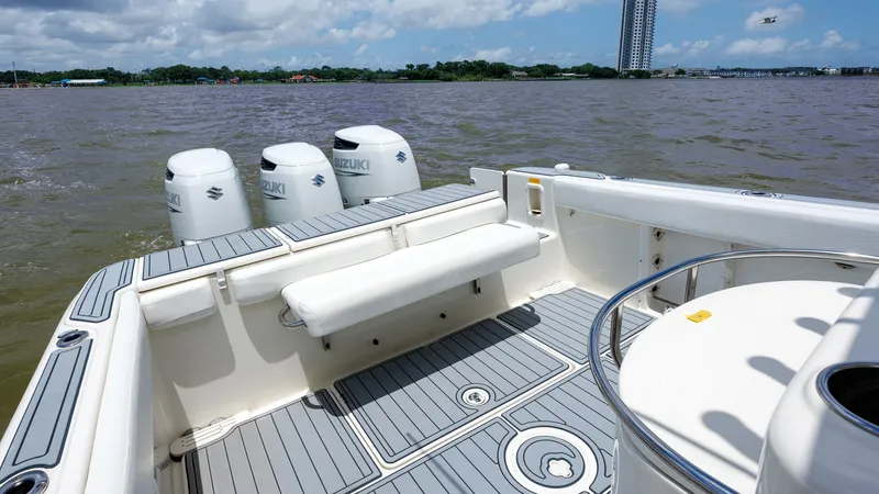 Slide: The Image of Spacious Aft Deck with Seating This 2005 Triton 351 Center Console features a spacious aft deck with comfortable seating, ideal for relaxation or socializing. The deck is adorned with durable non-slip flooring, ensuring safety and stability. Outfitted with triple Suzuki engines, this v - 6687465