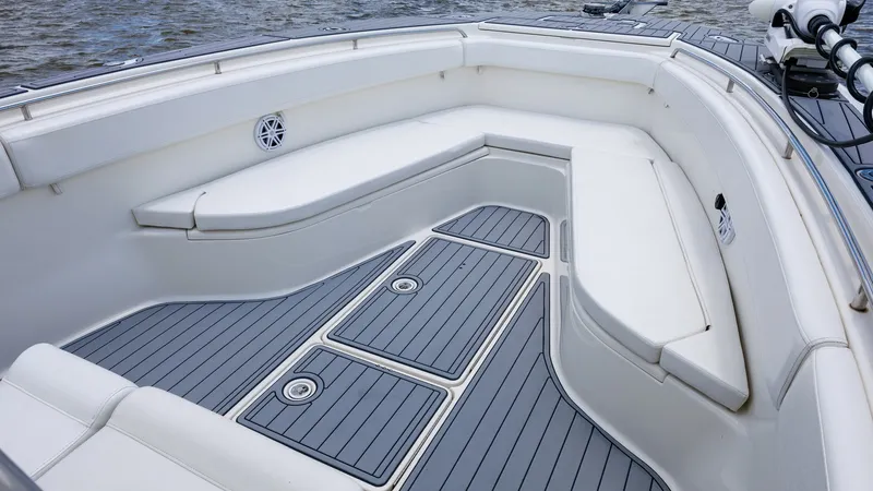 Slide: The Image of Spacious Bow Seating Area The bow of the 2005 Triton 351 Center Console features ample seating with cushioned benches, providing a comfortable space for relaxation and socializing. The sleek, non-slip decking ensures safety and style, while integrated speakers offer entertainment - 6687471