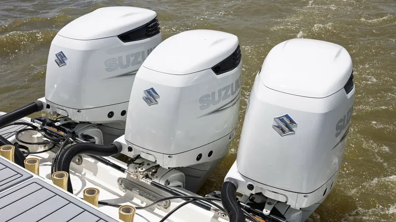Slide: The Image of Triple Suzuki Outboard Engines This image showcases the powerful triple Suzuki outboard engines on the 2005 Triton 351 Center Console. These engines provide exceptional performance and reliability, ideal for high-speed cruising and offshore adventures. The sleek design and robust const - 6687485