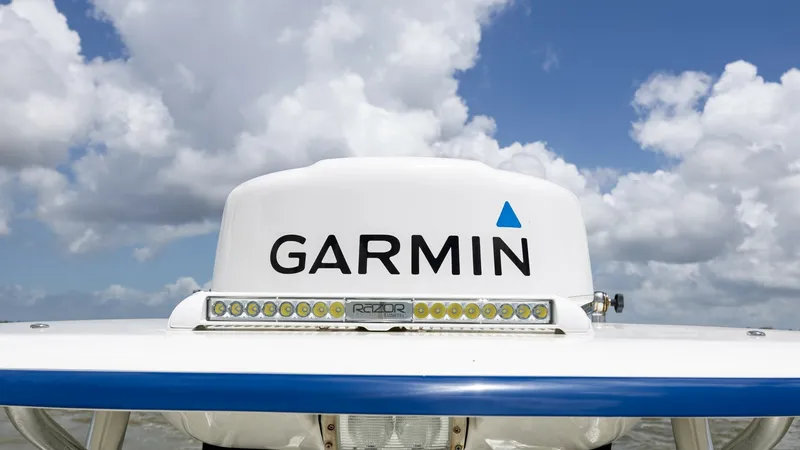 Slide: The Image of Radar and Antenna Setup This image showcases the advanced radar and antenna setup on the Triton 351 Center Console. The prominent Garmin dome ensures reliable navigation and communication, essential for any serious boater. Below the radar, an LED light bar provides enhanced visi - 6687479