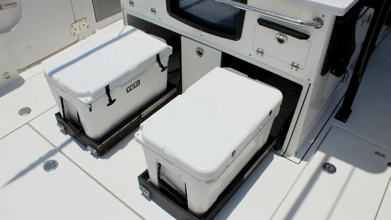 Slide: The Image of Fishing Station with Slide-Out Coolers This image showcases the functional fishing station on the Blackfin 332 Center Console, featuring dual slide-out Yeti coolers for easy access and storage. The integrated cabinetry offers additional storage and workspace, designed for efficiency during fis - 6687448