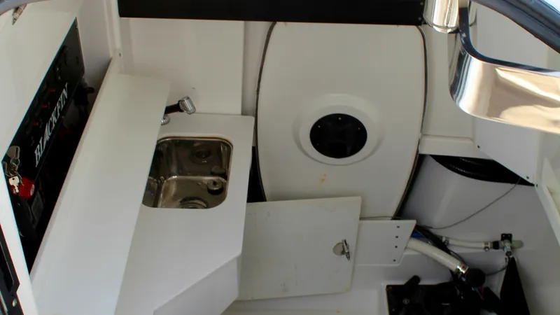 Slide: The Image of Interior Cabin with Sink Area This image showcases the compact interior cabin of the Blackfin 332 Center Console. The area features a practical stainless steel sink with a sleek countertop, ideal for quick clean-ups or meal prep. The space is efficiently designed, maximizing functiona - 6687446