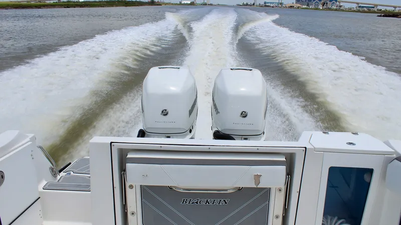 Slide: The Image of Aft View with Dual Engines This image showcases the powerful dual engines on the Blackfin 332 Center Console, 'Got Tuna'. The sleek design and impressive horsepower create a striking wake, highlighting the vessel's speed and performance. The clean, modern lines of the aft section e - 6687450