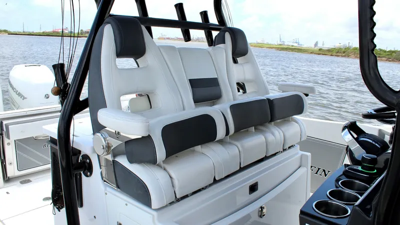 Slide: The Image of Helm Seating Area with Rod Holders The helm seating area of the 2020 Blackfin 332 Center Console features plush, ergonomic seats with high backrests for maximum comfort. This area is equipped with multiple rod holders, ideal for fishing enthusiasts. The sleek white and gray upholstery comp - 6687434
