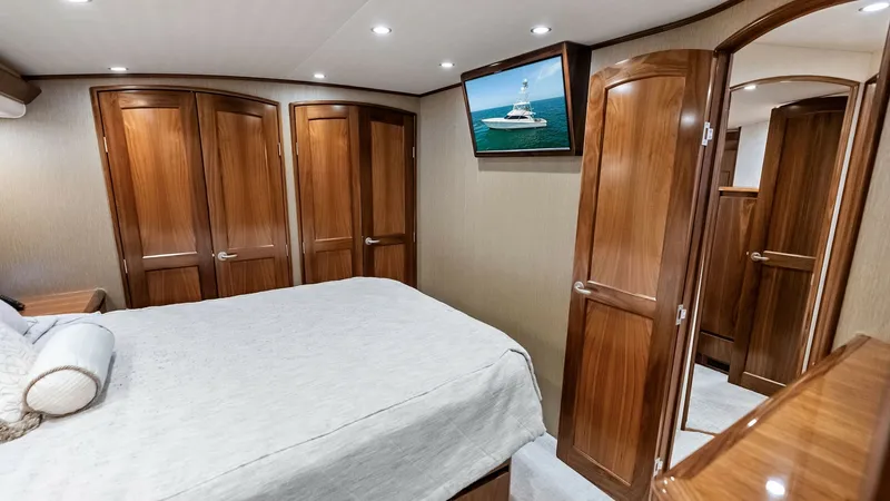 Slide: The Image of Luxurious Master Stateroom The master stateroom of the 2018 Viking 62 Convertible exudes elegance with its rich wood finishes and spacious design. The room features a plush queen-sized bed, ample storage with beautifully crafted cabinets, and a mounted flat-screen TV for entertainm - 8440051