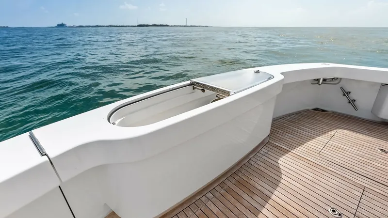 Slide: The Image of Aft Deck with Fish Box The aft deck of the 2018 Viking 62 Convertible features a spacious fish box, seamlessly integrated into the sleek teak decking. This area offers ample space for fishing enthusiasts, combining functionality with the elegance of its polished finishes. The o - 8440074