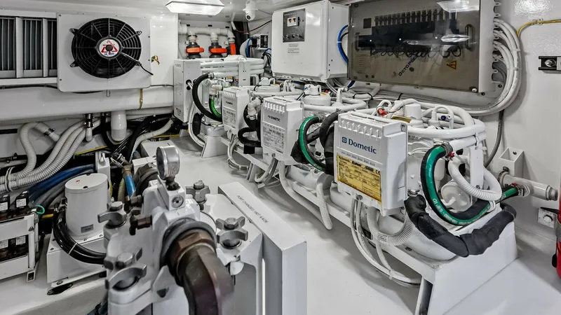 Slide: The Image of Engine Room with Dometic Units The engine room of the 2018 Viking 62 Convertible showcases advanced Dometic units, emphasizing the vessel's commitment to efficient and reliable onboard systems. The space is meticulously organized, featuring state-of-the-art electrical panels and well-a - 8440094