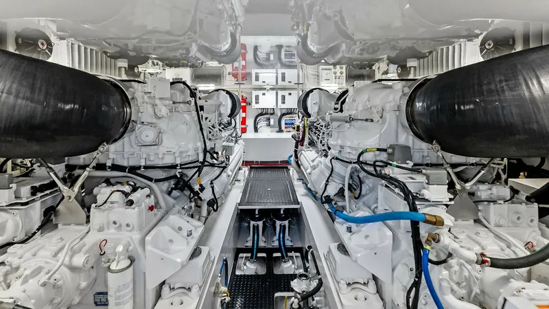 Slide: The Image of Engine Room with Twin Engines The engine room of the 2018 Viking 62 Convertible, 'Rollin' Deep', showcases twin powerful engines, meticulously arranged for optimal performance. The pristine white finish and organized layout emphasize the high standards of maintenance and engineering p - 8440087