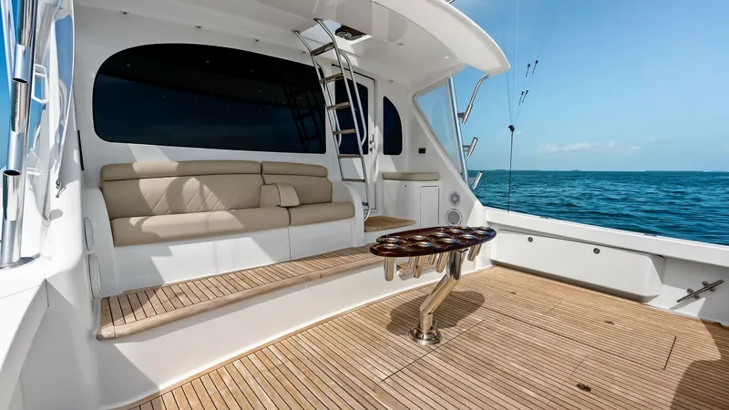 Slide: The Image of Spacious Cockpit with Teak Decking The cockpit of the 2018 Viking 62 Convertible showcases a spacious area with elegant teak decking, perfect for fishing or entertaining. The plush seating offers comfort and style, while the central table adds functionality for dining or relaxing. The larg - 8440066