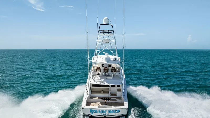 Slide: The Image of Aft View with Tuna Tower The Viking 62 Convertible, 'Rollin' Deep', showcases its impressive aft deck and towering tuna tower as it cruises through open waters. The spacious cockpit is perfect for fishing or lounging, with plush seating and ample storage. The tower provides eleva - 8440115