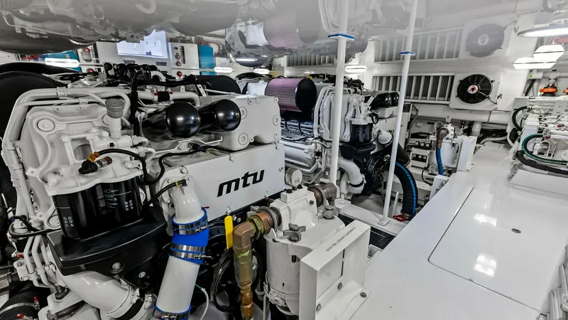 Slide: The Image of Engine Room with MTU Engines The engine room of the 2018 Viking 62 Convertible, 'Rollin' Deep', showcases powerful MTU engines, designed for optimal performance and efficiency. The space is meticulously organized, featuring state-of-the-art technology and easy access for maintenance. - 8440101