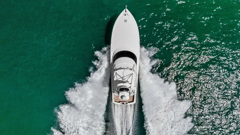 Slide: The Image of Aerial View of Bow in Motion This striking aerial shot captures the Viking 62 Convertible cutting through the water with elegance and power. The vessel's sleek design is highlighted by the clean lines of the bow as it creates a dynamic wake against the vibrant blue sea. The spacious - 8440118