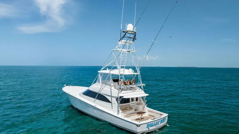 Slide: The Image of Aerial View of Viking 62 Convertible This image showcases the sleek lines and robust design of the 2018 Viking 62 Convertible, 'Rollin' Deep'. The spacious aft deck is designed for optimal fishing and leisure, complemented by the sturdy, functional tuna tower. The yacht's elegant profile gli - 8440106