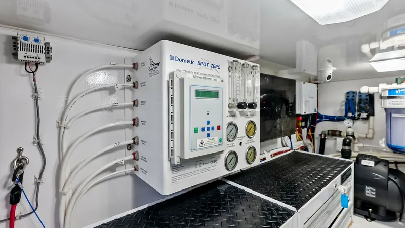 Slide: The Image of Advanced Water Filtration System The image showcases the state-of-the-art water filtration system aboard the 2018 Viking 62 Convertible, Rollin' Deep. Featuring a Dometic Spot Zero unit, the setup ensures pure water throughout the vessel. The neatly organized piping and control panels hi - 8440098
