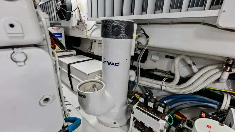 Slide: The Image of Engine Room with Seakeeper Gyro This image showcases the engine room of the 2018 Viking 62 Convertible, featuring a prominently installed Seakeeper Gyro system. The space is well-organized, with neatly arranged wiring and components, highlighting the vessel's meticulous engineering and - 8440100