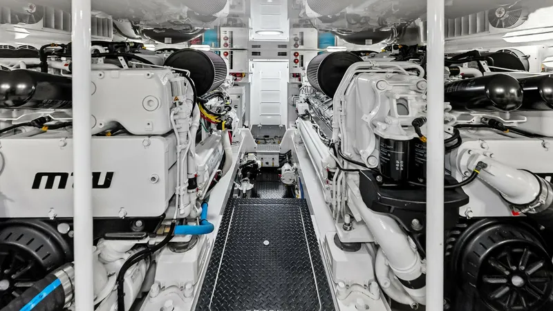 Slide: The Image of Engine Room with Twin Engines The engine room of the 2018 Viking 62 Convertible showcases a meticulously organized space with twin MTU engines. The clean, white finish and efficient layout ensure easy access for maintenance and inspection. This area reflects the vessel's commitment to - 8440086