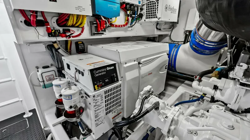 Slide: The Image of Engine Room with Generator Setup This image showcases the well-organized engine room of the 2018 Viking 62 Convertible, featuring a Cummins Onan generator. The space is meticulously arranged, highlighting the professional wiring and advanced power systems that ensure reliable performance - 8440088