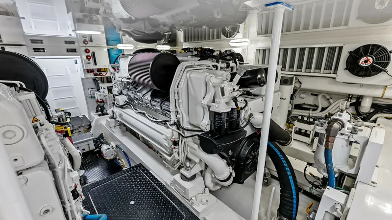 Slide: The Image of Engine Room with Twin Engines The engine room of the 2018 Viking 62 Convertible showcases twin high-performance engines, meticulously maintained for optimal efficiency. The space is well-lit and organized, featuring easy-access panels and advanced ventilation systems. Durable flooring - 8440096