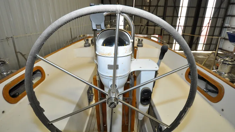 Slide: The Image of 1984 Bristol 41.1 | Petrel Yacht helm with steering wheel and navigation equipment in a boatyard. - 6523064