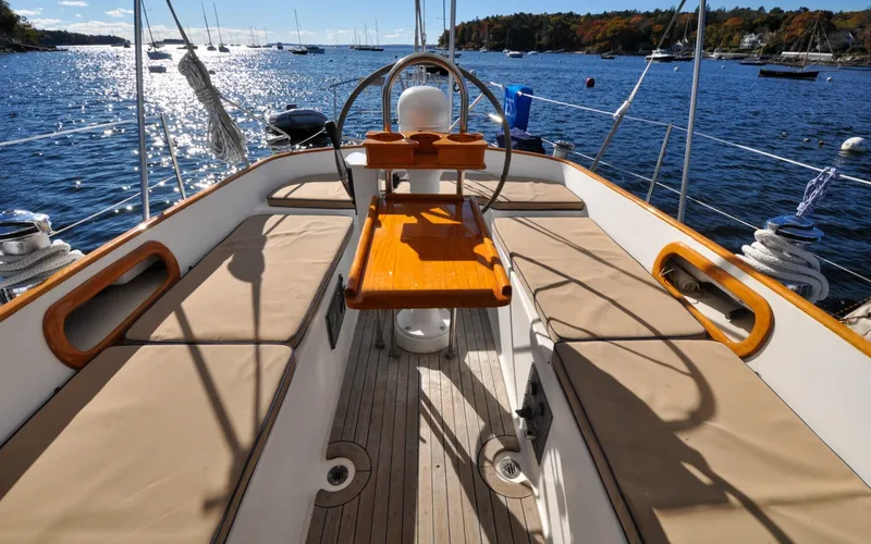 Slide: The Image of 1984 Bristol 41.1 | Petrel Cockpit of 1984 Bristol 41.1 sailboat on a sunny day, overlooking a scenic harbor. - 6525684
