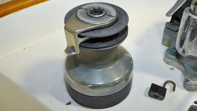Slide: The Image of 1984 Bristol 41.1 | Petrel Sailboat winch with a padlock on a white surface. - 6523052