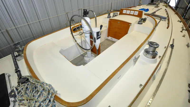 Slide: The Image of 1984 Bristol 41.1 | Petrel Sailboat cockpit with steering wheel and winches in a marina. - 6523071