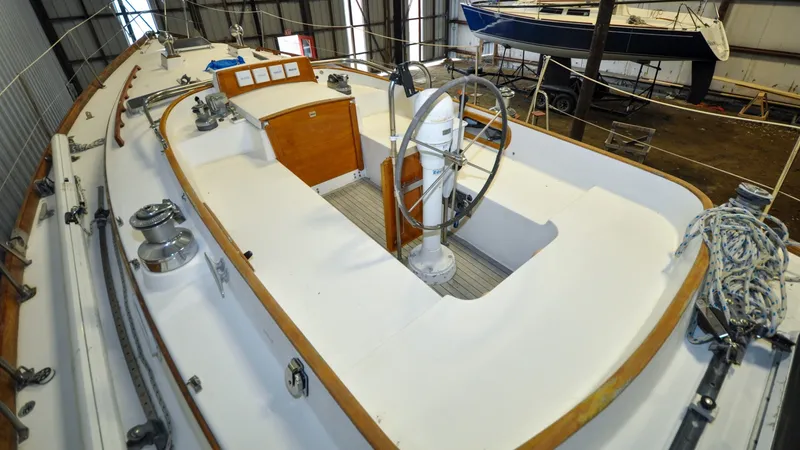 Slide: The Image of 1984 Bristol 41.1 | Petrel Sailboat interior with steering wheel, docked in a boatyard. - 6523070