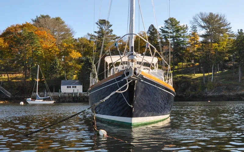 Slide: The Image of 1984 Bristol 41.1 | Petrel Sailboat anchored in scenic autumn harbor with colorful trees. - 6523152