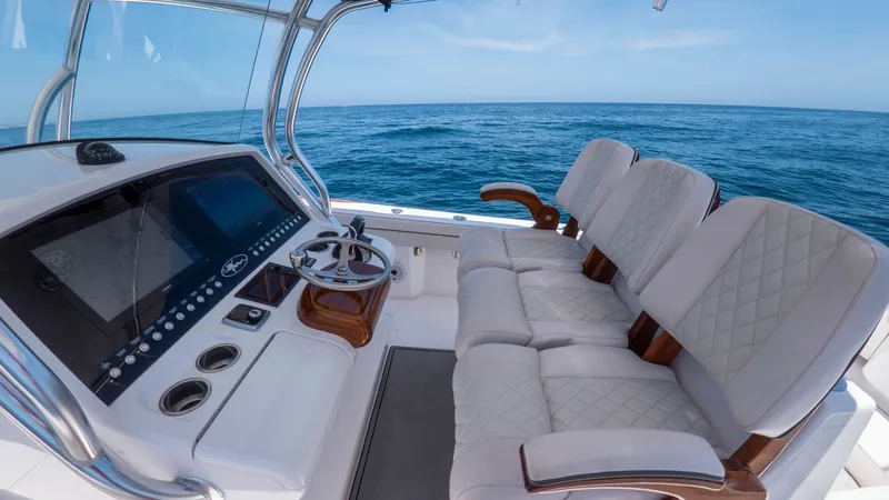 Slide: The Image of Helm Station with Seating Area The helm station of the 2022 LONE STAR II V-37 by Valhalla Boatworks features a sleek, modern control panel with advanced navigation displays. The spacious seating area is adorned with plush, diamond-stitched upholstery, offering comfort and style during - 6536767