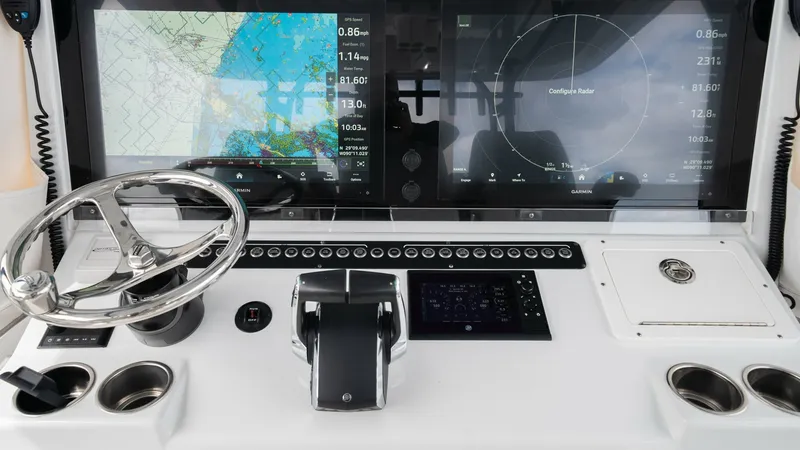 Slide: The Image of Modern Helm Station with Electronics The helm station of the 2023 Freeman 42 LR 'Fortunate Son' showcases advanced navigation technology with dual multifunction displays. The sleek, ergonomic design includes a stainless steel steering wheel, ensuring precise handling. Ample cup holders and i - 6725107