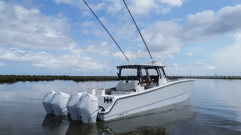 Slide: The Image of Aft View with Quad Outboards The 2023 Freeman 42 LR 'Fortunate Son' showcases its robust aft design with four powerful Mercury outboards, ensuring top-tier performance and speed. The sleek hull is complemented by a spacious deck, perfect for fishing or leisure. This modern vessel exu - 6725126