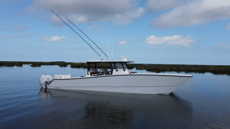 Slide: The Image of Side Profile of Freeman 42 LR The sleek side profile of the 2023 Freeman 42 LR showcases its elegant lines and robust design. This vessel, named Fortunate Son, is equipped with powerful outboard engines, ensuring high performance and efficiency on the water. The spacious deck and adva - 6725119
