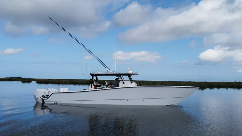 Slide: The Image of Side Profile of Freeman 42 LR This image showcases the sleek side profile of the 2023 Freeman 42 LR, named 'Fortunate Son.' The vessel's elegant lines and robust hull design are highlighted, offering a glimpse of its superior craftsmanship. Equipped with powerful outboard engines, thi - 6725118