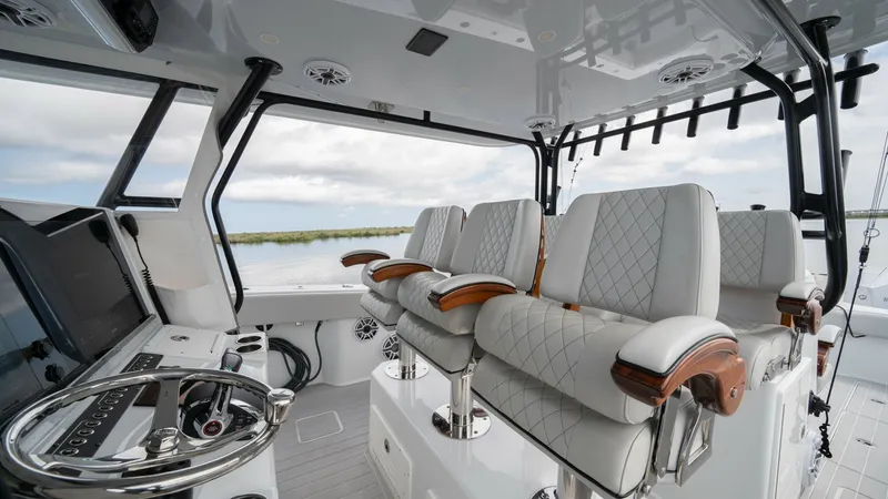 Slide: The Image of Helm Seating and Console Area The helm area of the 2023 Freeman 42 LR features luxurious quilted seating with elegant wooden armrests, offering both comfort and style. The console is equipped with state-of-the-art navigation technology, ensuring a smooth and precise sailing experience - 6725106