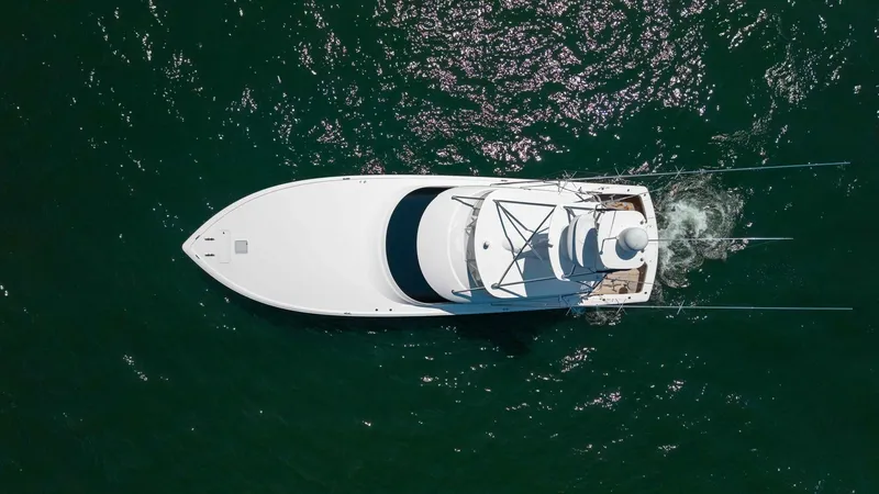 Slide: The Image of Aerial View of Viking 62 Convertible This striking aerial shot showcases the sleek, aerodynamic design of the Viking 62 Convertible. The vessel's spacious deck and elegant lines are complemented by the shimmering waters below, highlighting its superior craftsmanship and performance capabilit - 6711711