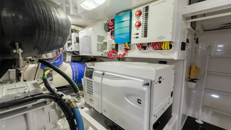 Slide: The Image of Engine Room with Electrical Systems This image showcases the well-organized engine room of the 2020 Viking 62 Convertible. Notable features include state-of-the-art electrical systems and a robust generator, ensuring reliable power and performance. The clean layout and meticulous wiring hig - 6711705