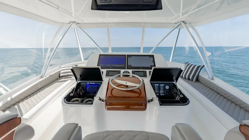 Slide: The Image of Flybridge Helm with Electronics The flybridge helm of the 2020 Viking 62 Convertible offers an advanced navigation setup with state-of-the-art electronic displays. The helm features a beautifully crafted wooden steering wheel and dual captain chairs with luxurious upholstery. Forward se - 6711694